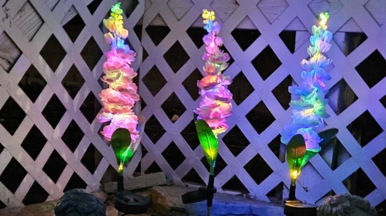glowing fake flowers near a white fence