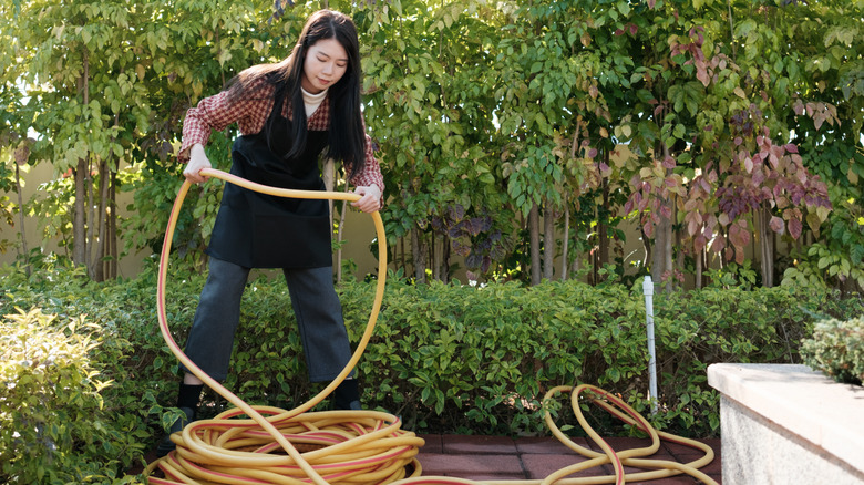 A person handling a long and tangled hose