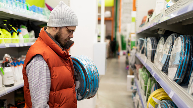 Man shops for garden hoses.