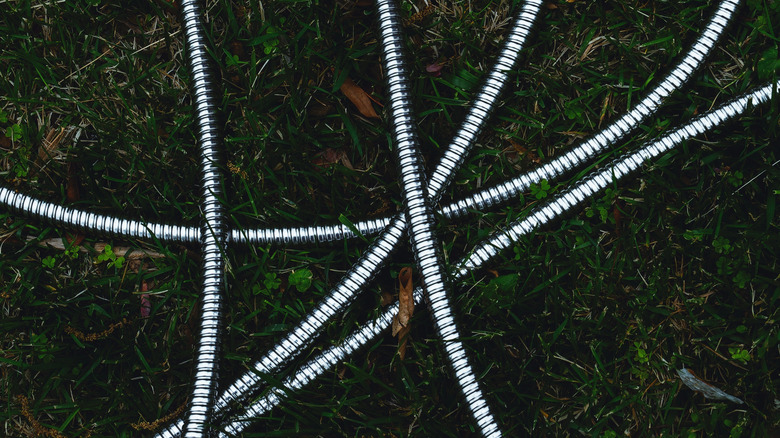 stainless steel garden hose on grass.