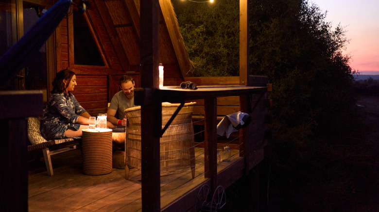 Couple on a deck at dusk with some patio lighting