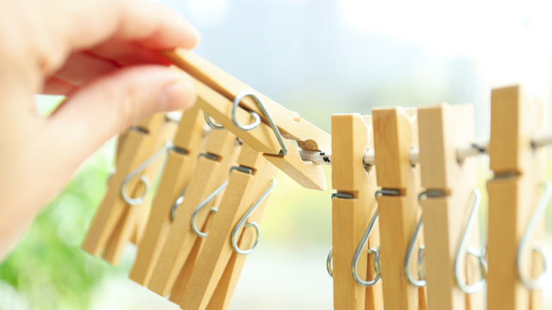Someone putting a clothespin on a line of clothespins.