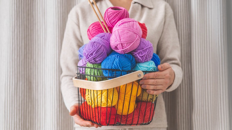 woman holding colorful yarn basket
