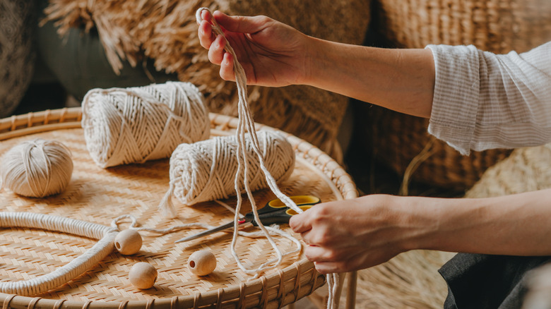 Woman's hands untangling white rope