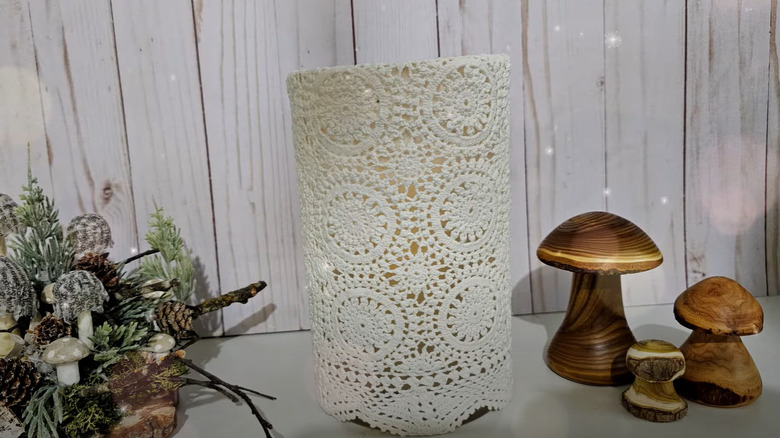 A screenshot of a vase covered with a vintage doily