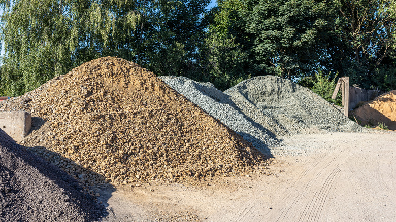Large piles of fill gravel and fill sand sitting outside