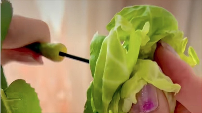 A wooden bowl filled with Brussels sprouts