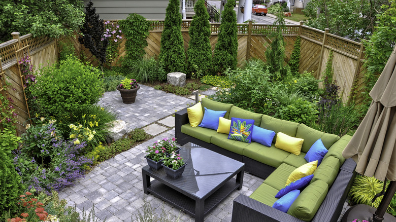 small patio surrounded by plants and privacy fencing