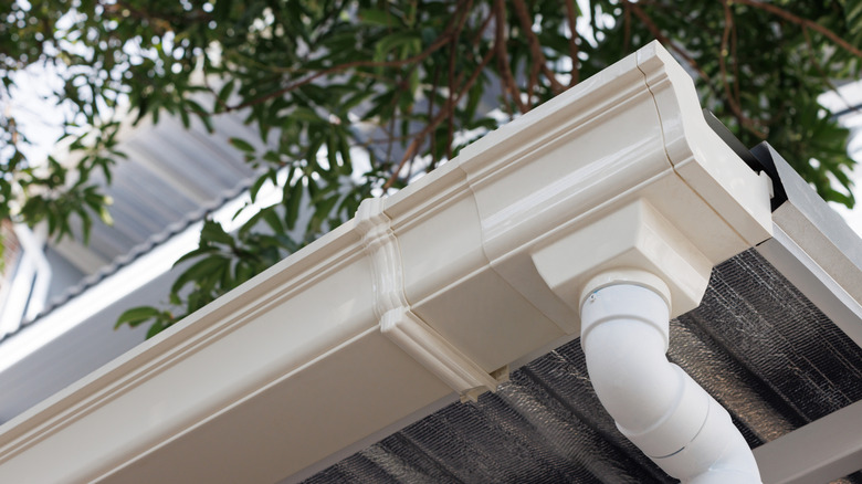 Closeup of a white plastic eavestrough viewed from below