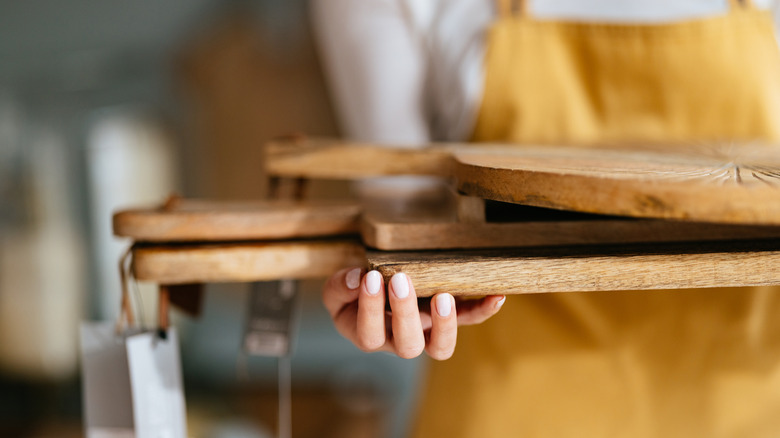 Someone holding a stack of wooden cutting boards