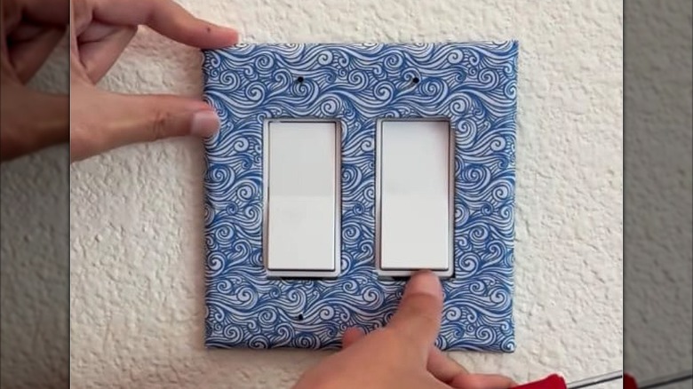 a wall plate covered in a wave patterned sheet of origami