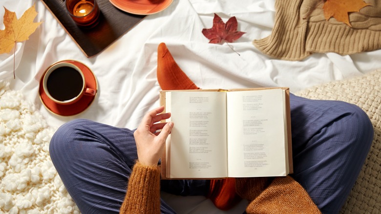 person reading book with coffee cup
