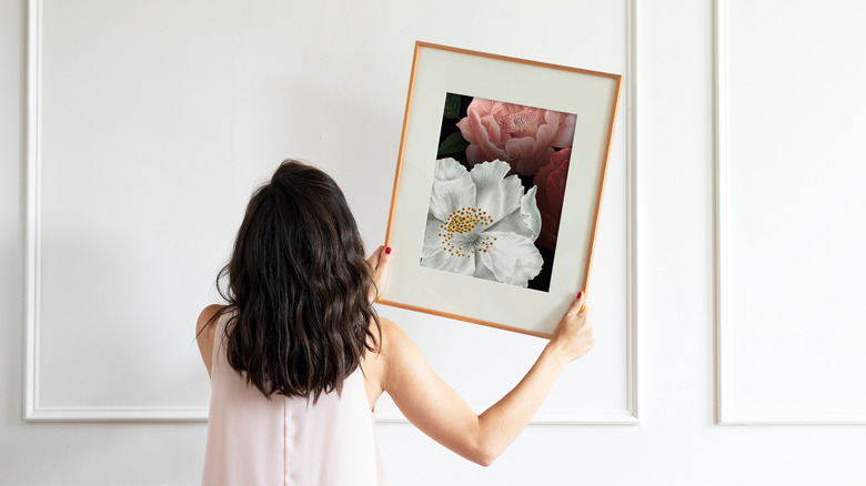 person hanging a photo