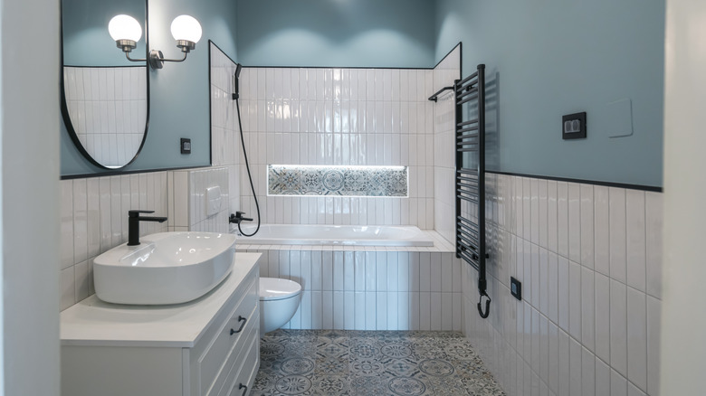 Modern bathroom with half-tiled walls and blue paint