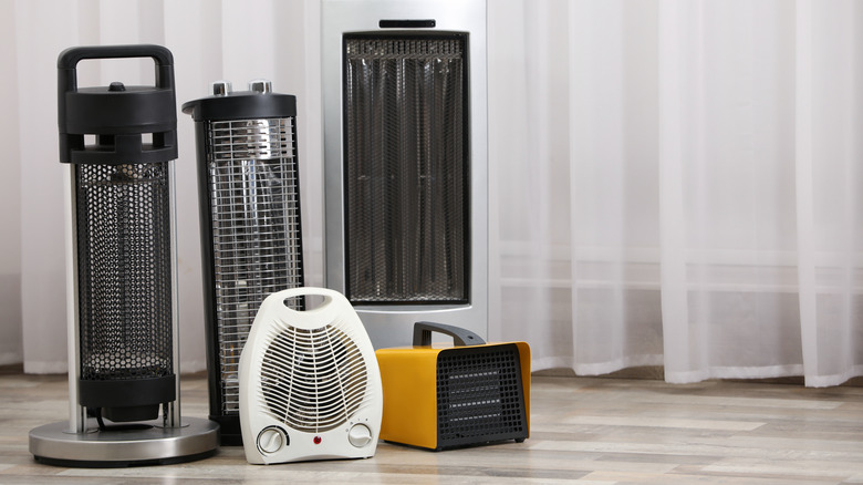 Different types of space heaters displayed on a floor