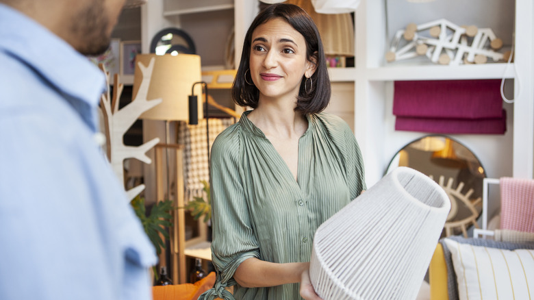 woman holding white table lamp