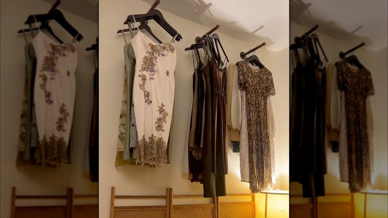 Clothes handing from brackets above a bed