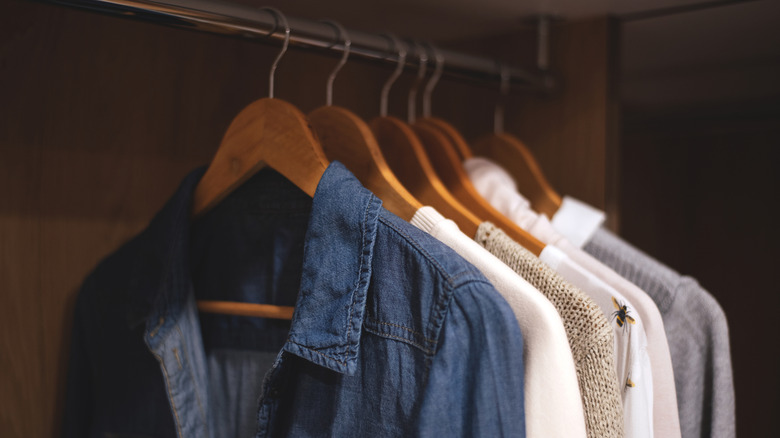 Shirts and other clothing items hanging on classic wood hangers