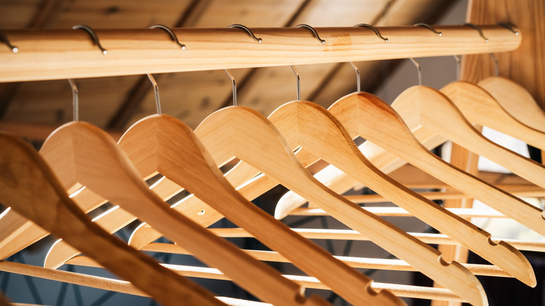 Wooden hangers with notches hanging on a wooden rod