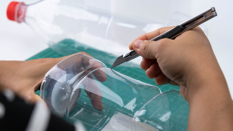 Man cutting water bottle