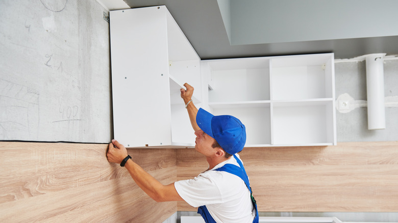 Man installing cabinets by himself