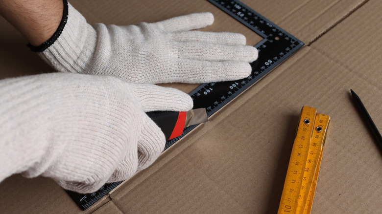 A person cutting pieces of cardboard with a utility knife
