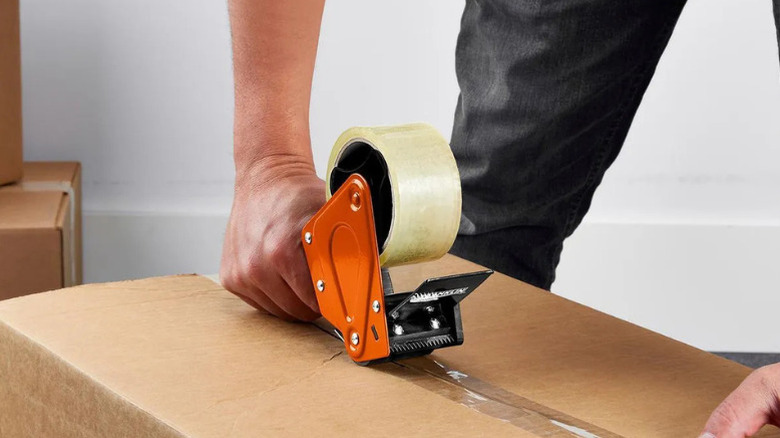 Close-up of a man using Franklin's 1.88 in. x 55 yd. Heavy Duty Packaging Tape Gun