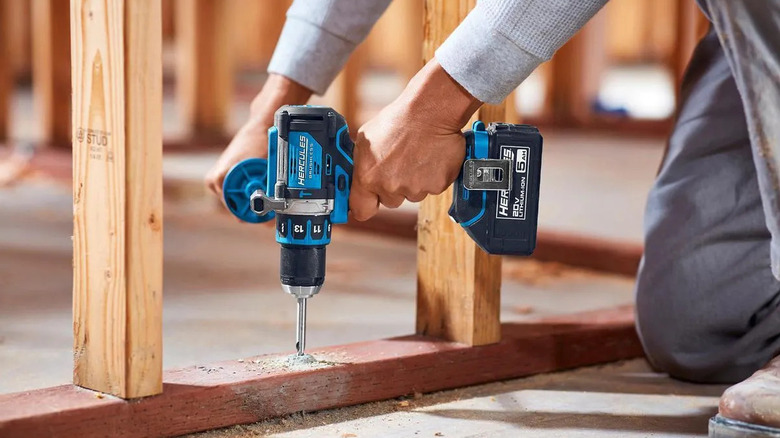 A close-up of a man using Hercules' 20V Brushless Compact Hammer Drill