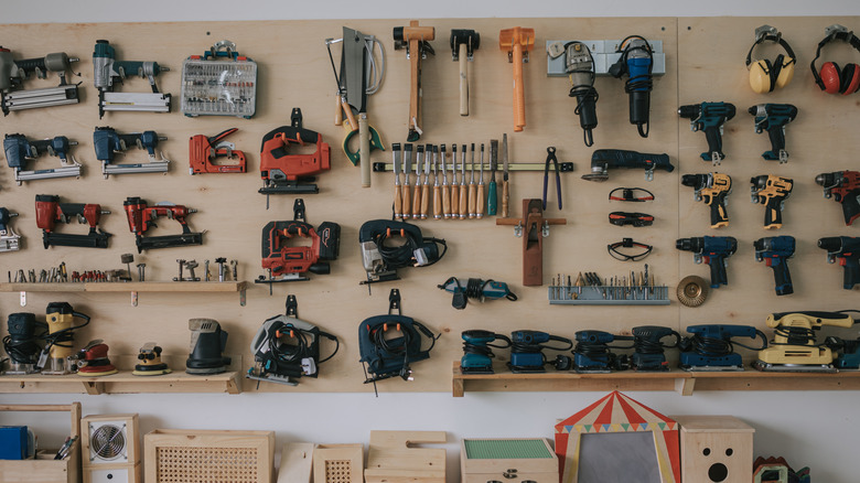 A garage wall hung with various hand tools and power tools