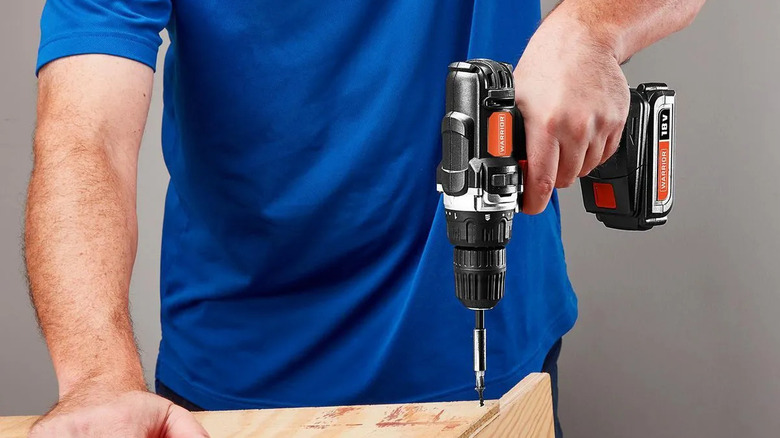 Close-up of a man using a Warrior power drill