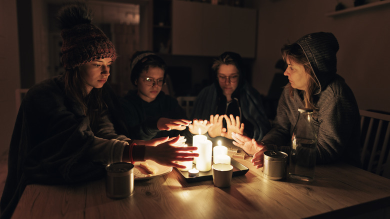 family gathers around candles blackout