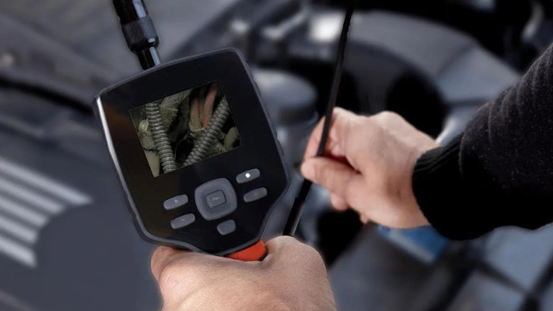 A man using Ames Instruments' 2.7 inch Color Compact Digital Inspection Camera