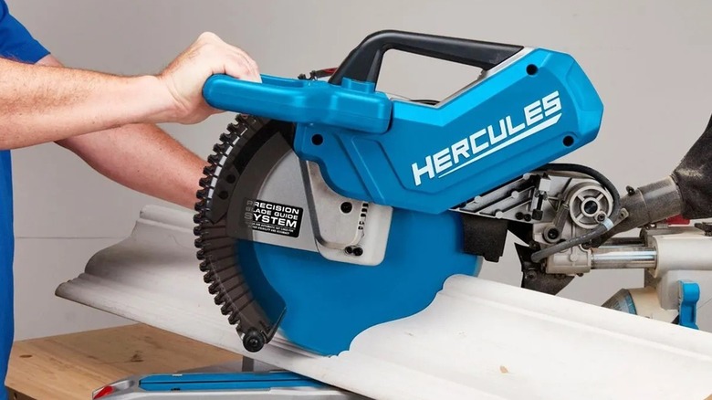 Person using a blue Harbor Freight Hercules miter saw