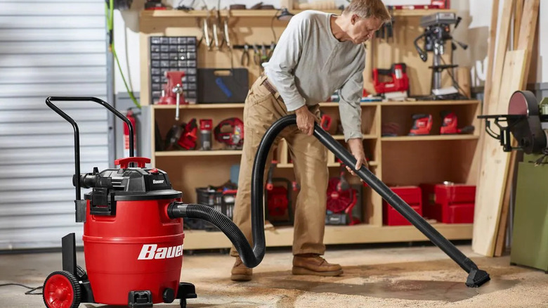A man using Bauer's 16 Gallon Wet/Dry Vacuum with Cart