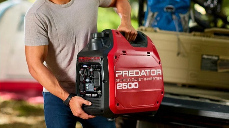 Man carrying a Predator 2500 inverter generator.