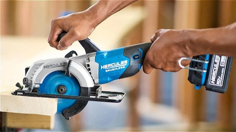 Hands using a Hercules brushless compact circular saw to cut wood.