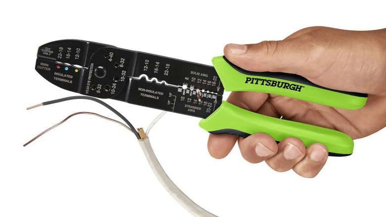 A person cutting electrical wires with the Pittsburgh multipurpose tool.