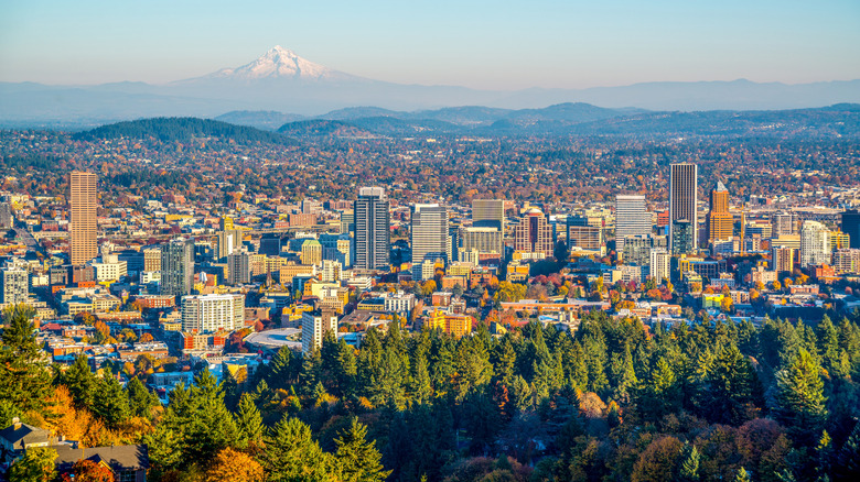 Skyline of Portland, Oregon and Mount Hood, the city framed by green trees shifting into autumn oranges