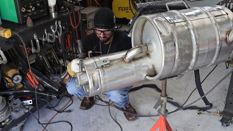 Man cutting metal keg for DIY smoker