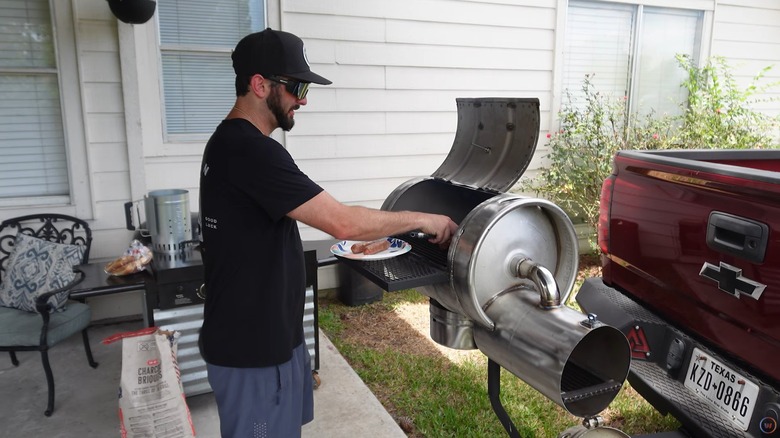 Man grilling on a custom keg grill that's attached to a pickup truck hitch