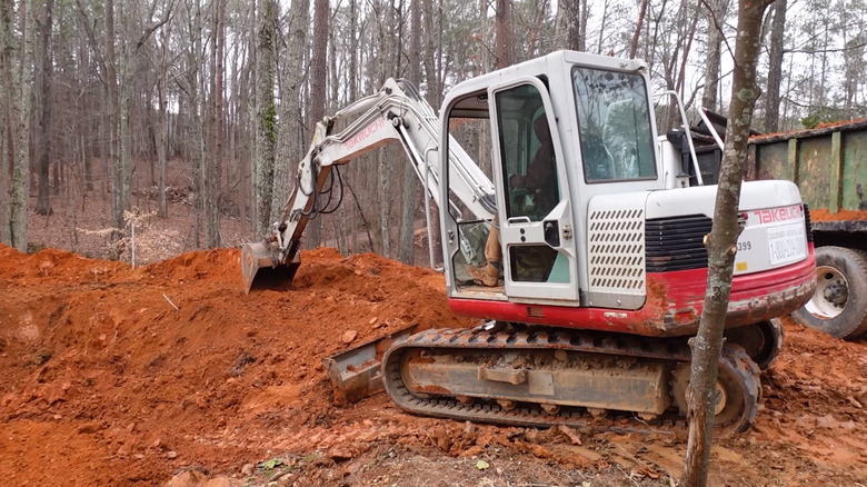 A small excavator digging soil out of the ground