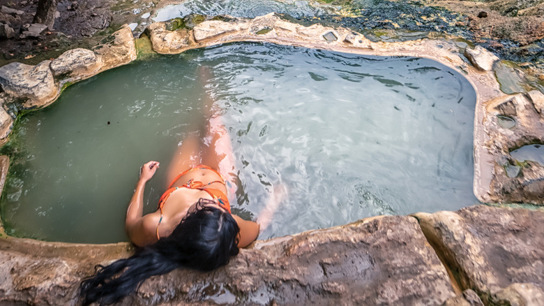 A woman in a spring tub outdoors