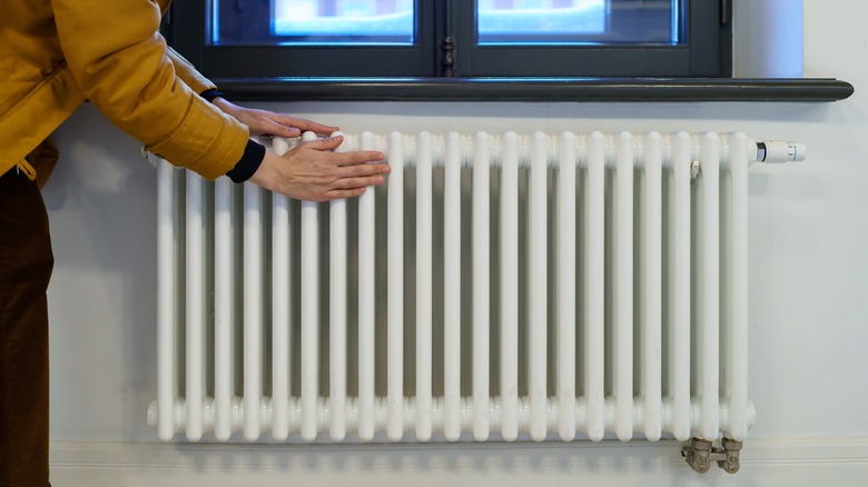 Woman checking radiator temperature