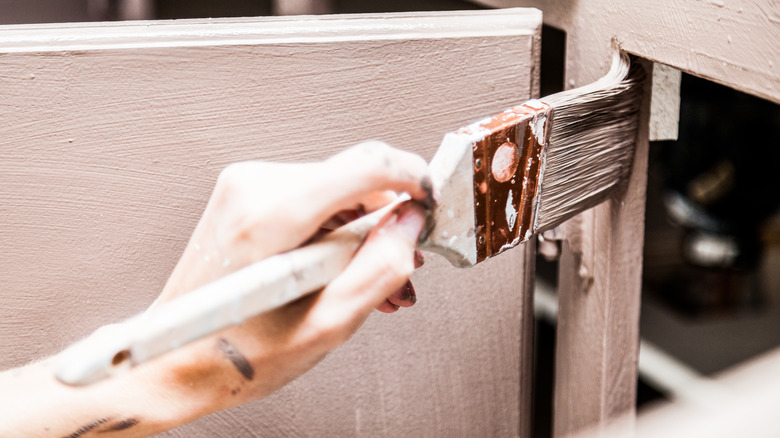 person painting cabinets