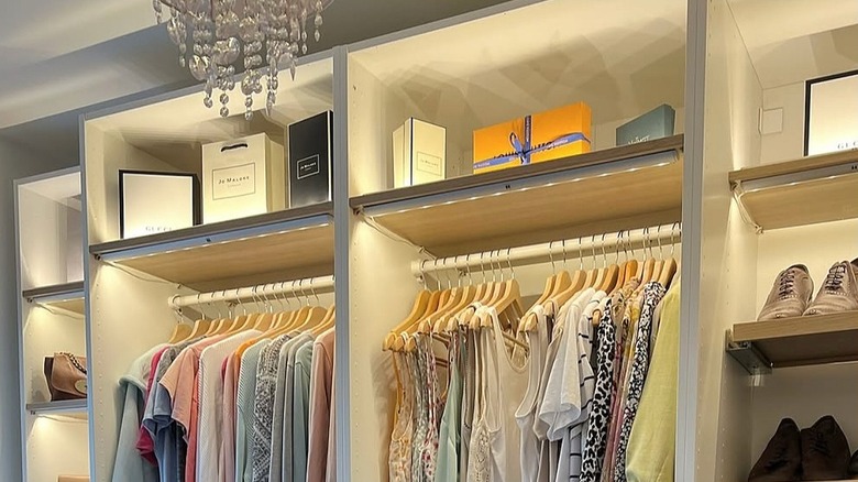 Closet with light strips underneath shelves