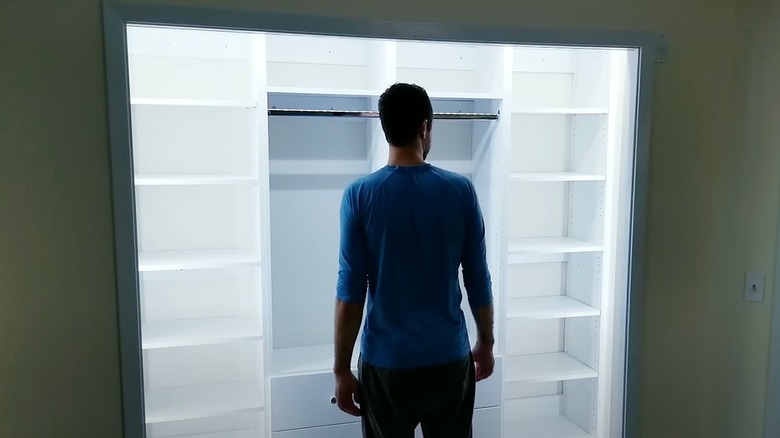 Man standing inside a closet with lights on