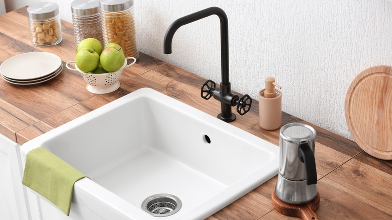 farmhouse kitchen sink with black faucet