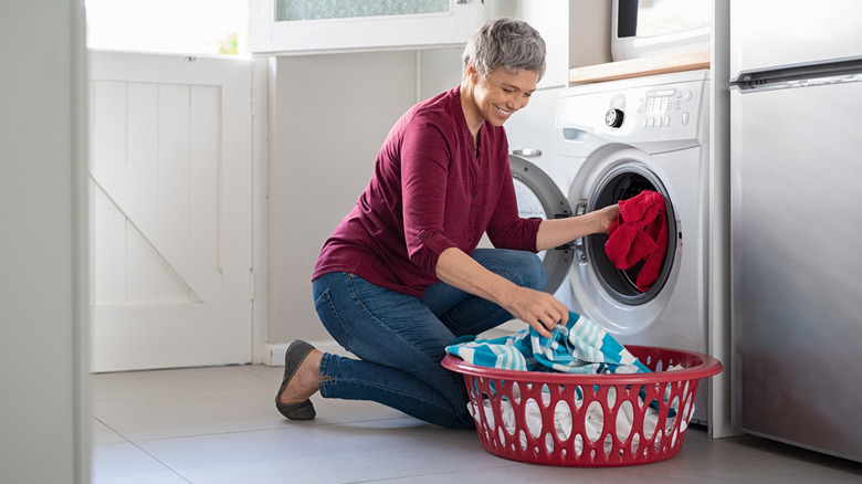 senior woman loading washing machine