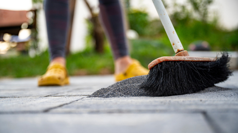 sweeping sand in driveway