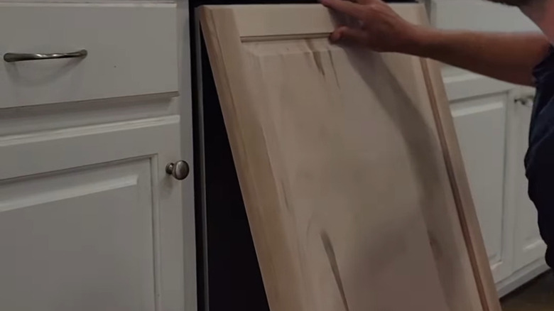 Person DIYing front panel on dishwasher for panel-ready look